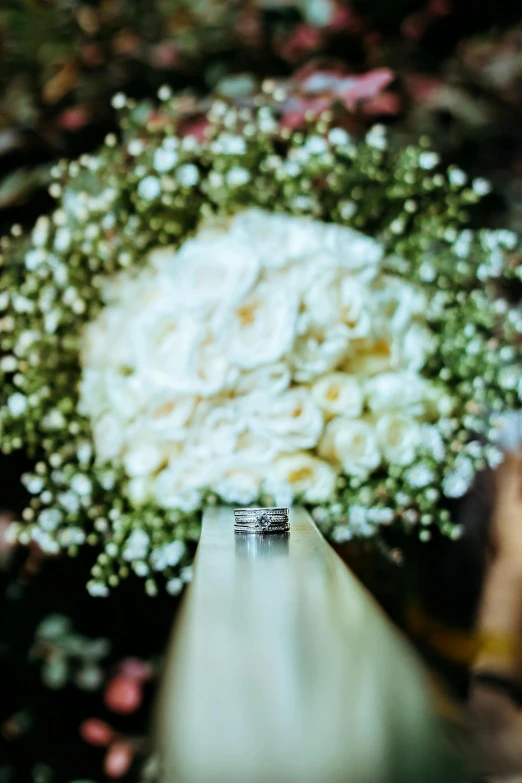 a couple of wedding rings sitting on top of a bouquet, in the distance, on display, slide show, iconic scene