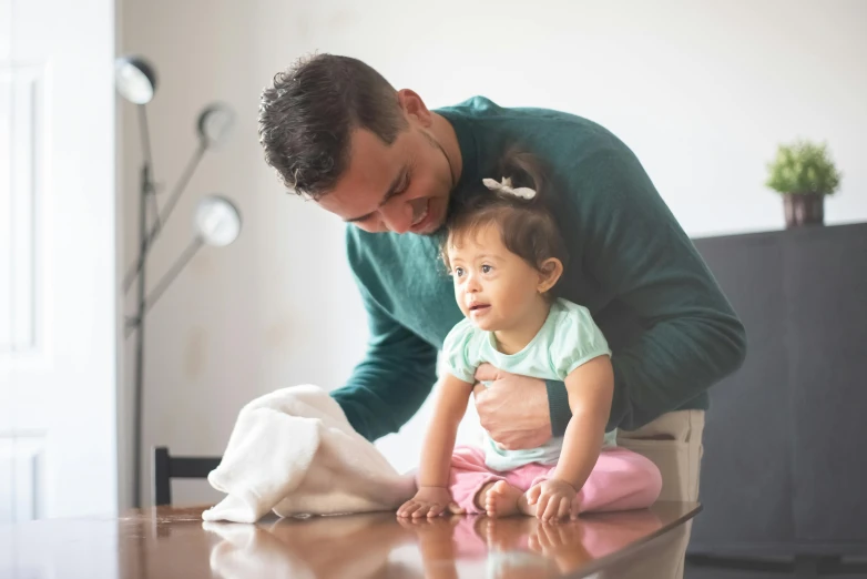 a man playing with a baby on the floor, pexels contest winner, hurufiyya, sitting at a table, avatar image, caring fatherly wide forehead, australian