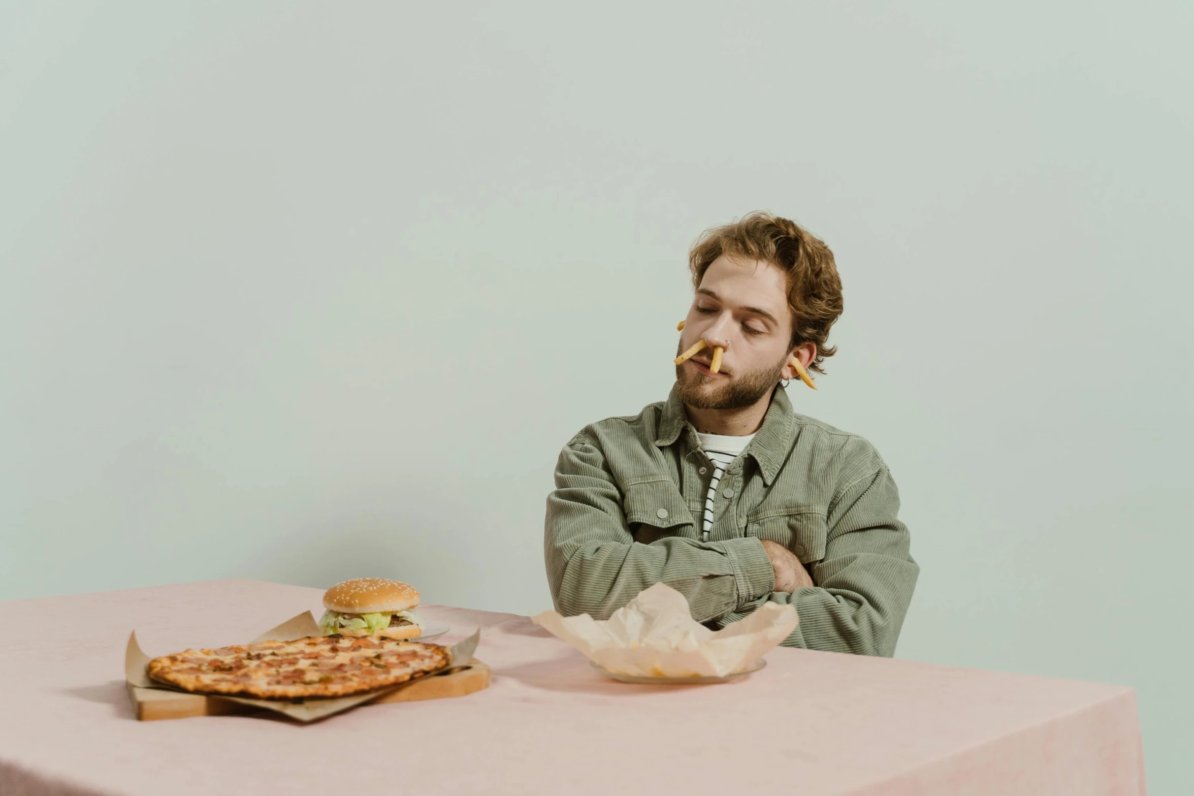 a man sitting at a table with a plate of food in front of him, an album cover, by Elsa Bleda, pexels contest winner, eating a pizza, thinking pose, on a pale background, asmongold