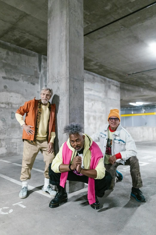 a group of men standing next to each other in a parking garage, an album cover, unsplash, graffiti, diverse outfits, mrbeast, 50 years old men, 3 actors on stage