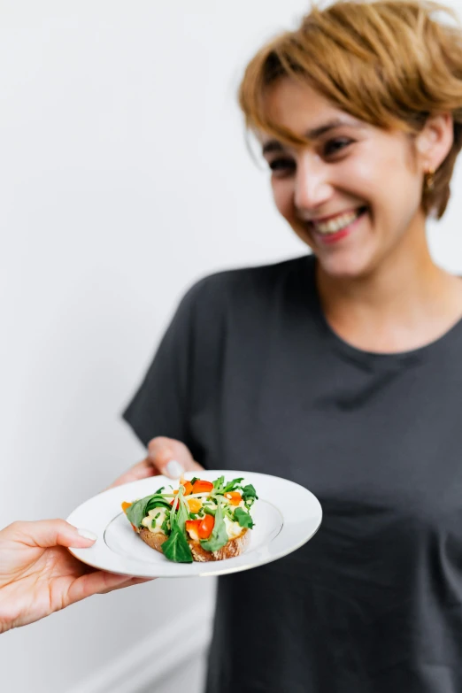 a woman holding a plate with a salad on it, by Nicolette Macnamara, pexels contest winner, white bg, ( waitress ) girl, lachlan bailey, product introduction photo