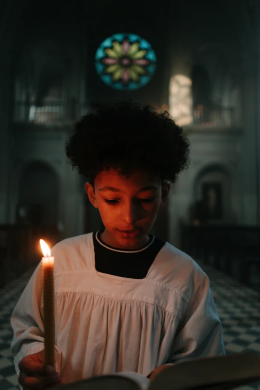 a young girl holding a candle in a church, an album cover, pexels, ashteroth, young boy, ignant, [ cinematic