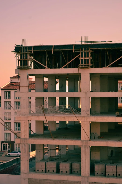 a very tall building that is under construction, inspired by Elsa Bleda, unsplash, picture of a loft in morning, pink concrete, soviet apartment buildings, 15081959 21121991 01012000 4k