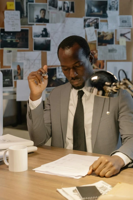a man sitting at a desk in front of a computer, pexels contest winner, adut akech, business attire, trending on imdb, architect