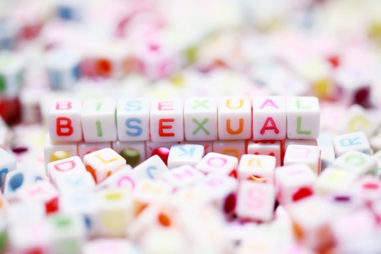 a pile of dice pieces with the word bisexual spelled on them, an album cover, trending on pexels, photograph credit: ap, pastel', lewd, maxwell boas