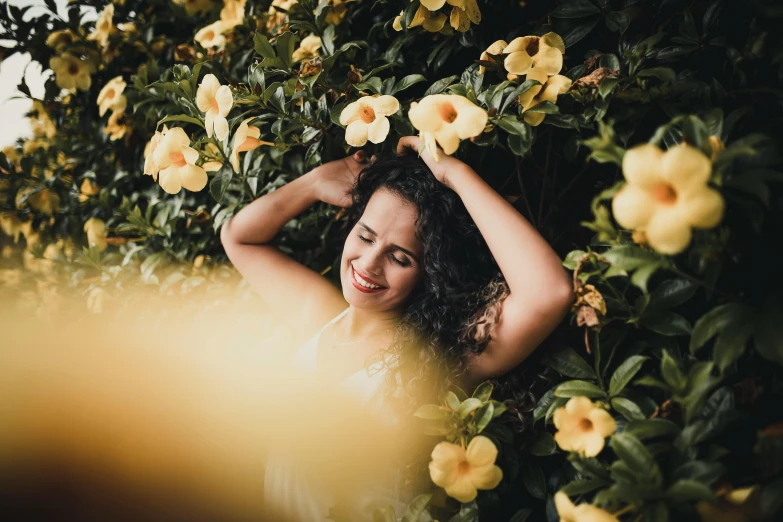 a woman standing in a field of yellow flowers, pexels contest winner, laying on roses, avatar image, playful smile, beautiful mexican woman