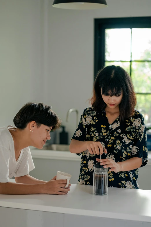 a woman standing next to a man in a kitchen, by Ruth Jên, pexels contest winner, process art, drinking coffee, teaching, on a white table, gif