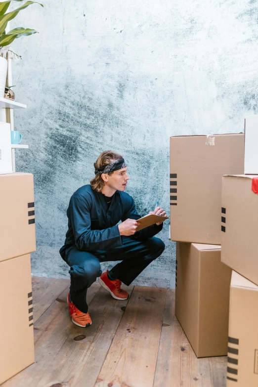 a man kneeling in front of a pile of cardboard boxes, a cartoon, pexels contest winner, renaissance, inspect in inventory image, location in a apartment, studio photo, lachlan bailey