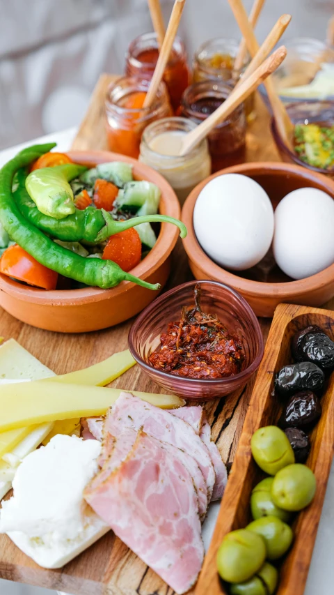 a wooden tray filled with different types of food, inspired by Kalervo Palsa, breakfast at las pozas, slide show, eggs, olive