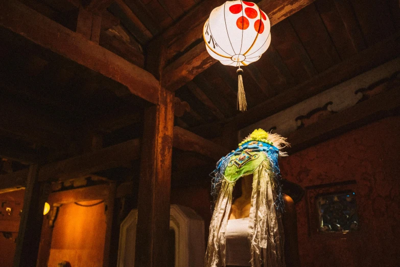 a dress on a mannequin in a room, by Aya Goda, unsplash, arts and crafts movement, kongming lanterns in the sky, feathered headdress, in a medieval tavern at night, inside house in village