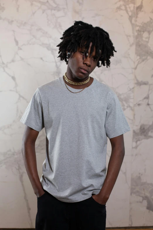 a man with dreadlocks standing in front of a wall, outlive streetwear collection, grey and silver, neck zoomed in, solid colours