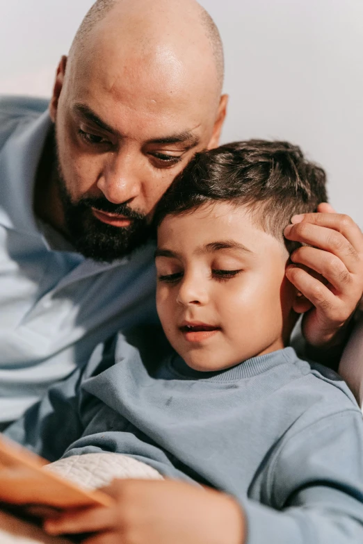 a man reading a book to a young boy, pexels contest winner, hurufiyya, eeg nodes on scalp, middle eastern skin, surgeon, soft details