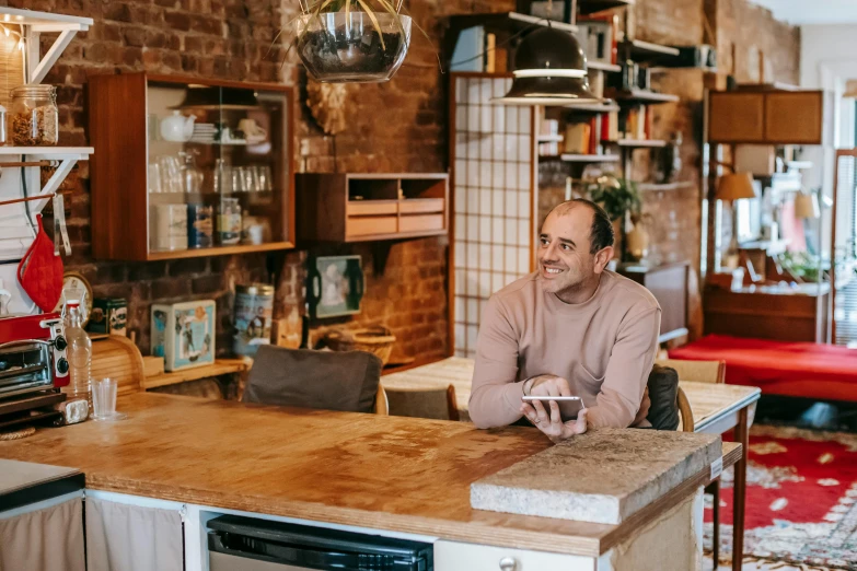 a man sitting at a counter in a kitchen, pexels contest winner, jerry seinfeld, in chippendale sydney, cozy environment, brown