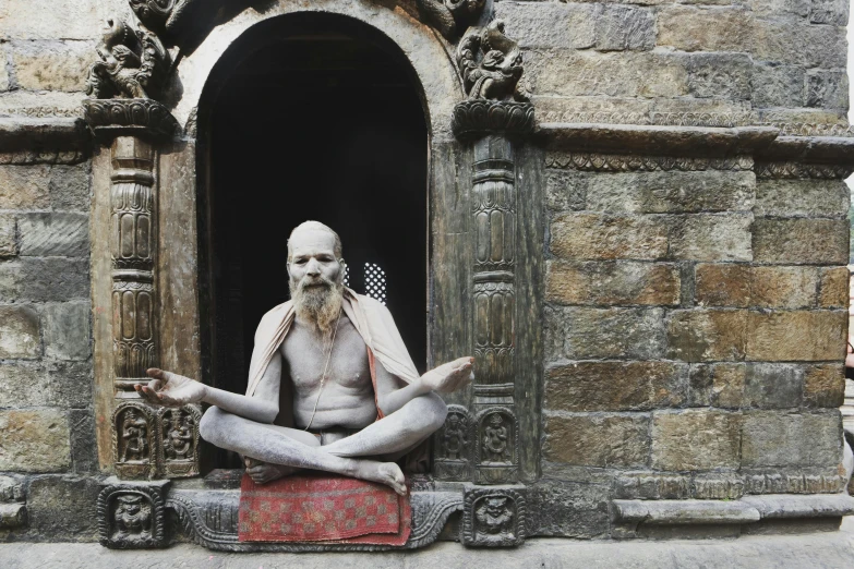 a statue of a man sitting in a doorway, inspired by Steve McCurry, pexels contest winner, nepali architecture buildings, yoga, clothed in ancient, ancient”