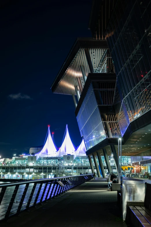 a couple of benches sitting next to a body of water, by Dave Melvin, pexels contest winner, modernism, spaceport docking bay at night, asymmetrical spires, vancouver, canopies