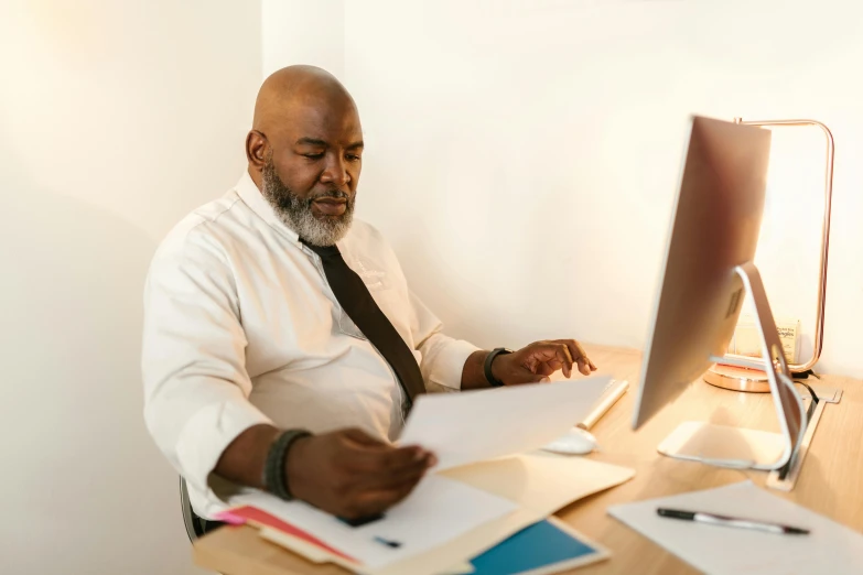 a man sitting at a desk in front of a computer, by Carey Morris, pexels contest winner, huell babineaux, trying to read, official screenshot, middle aged