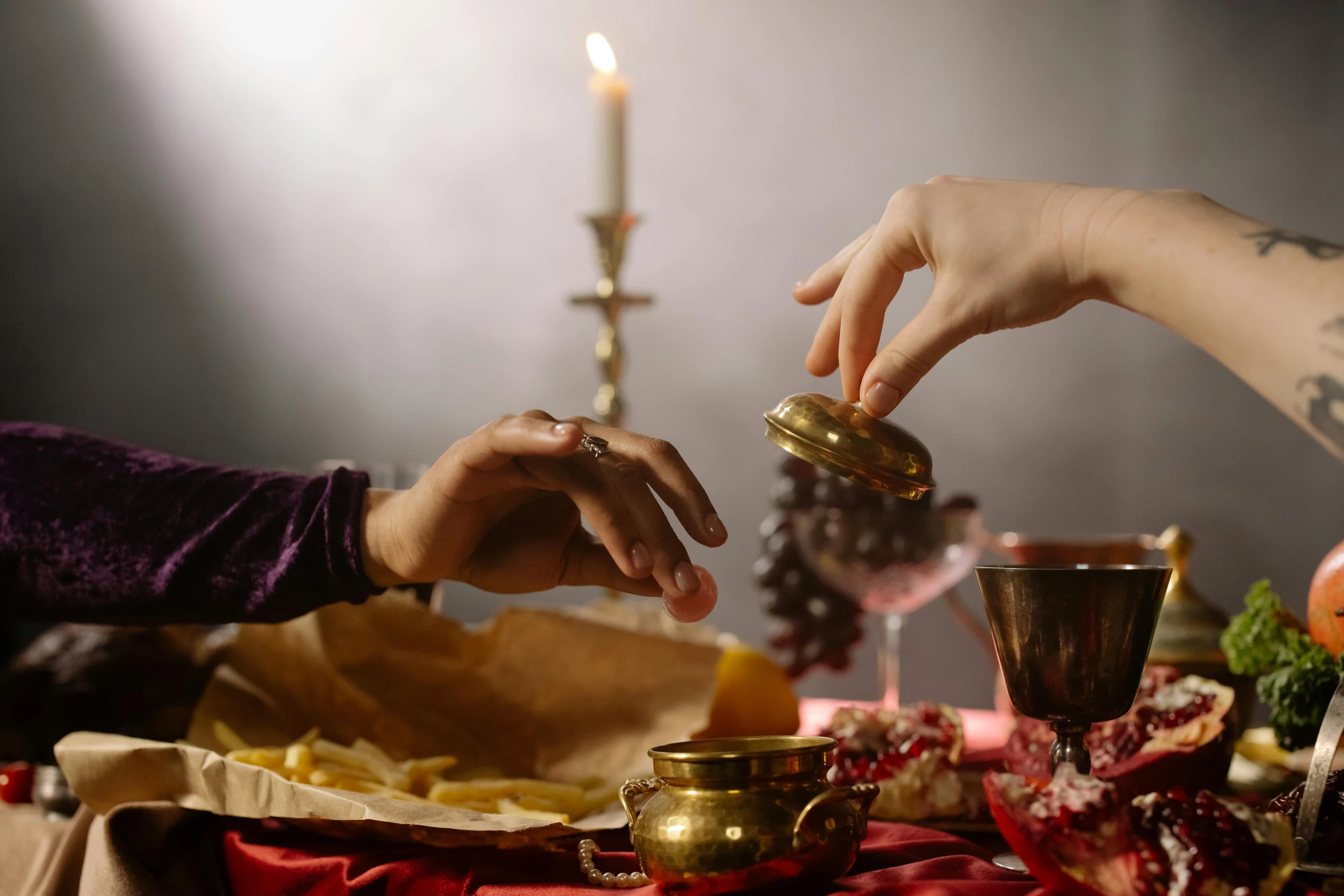 a couple of people that are sitting at a table, a still life, trending on pexels, renaissance, casting a protection spell, gold and red, dinner is served, ground level shot