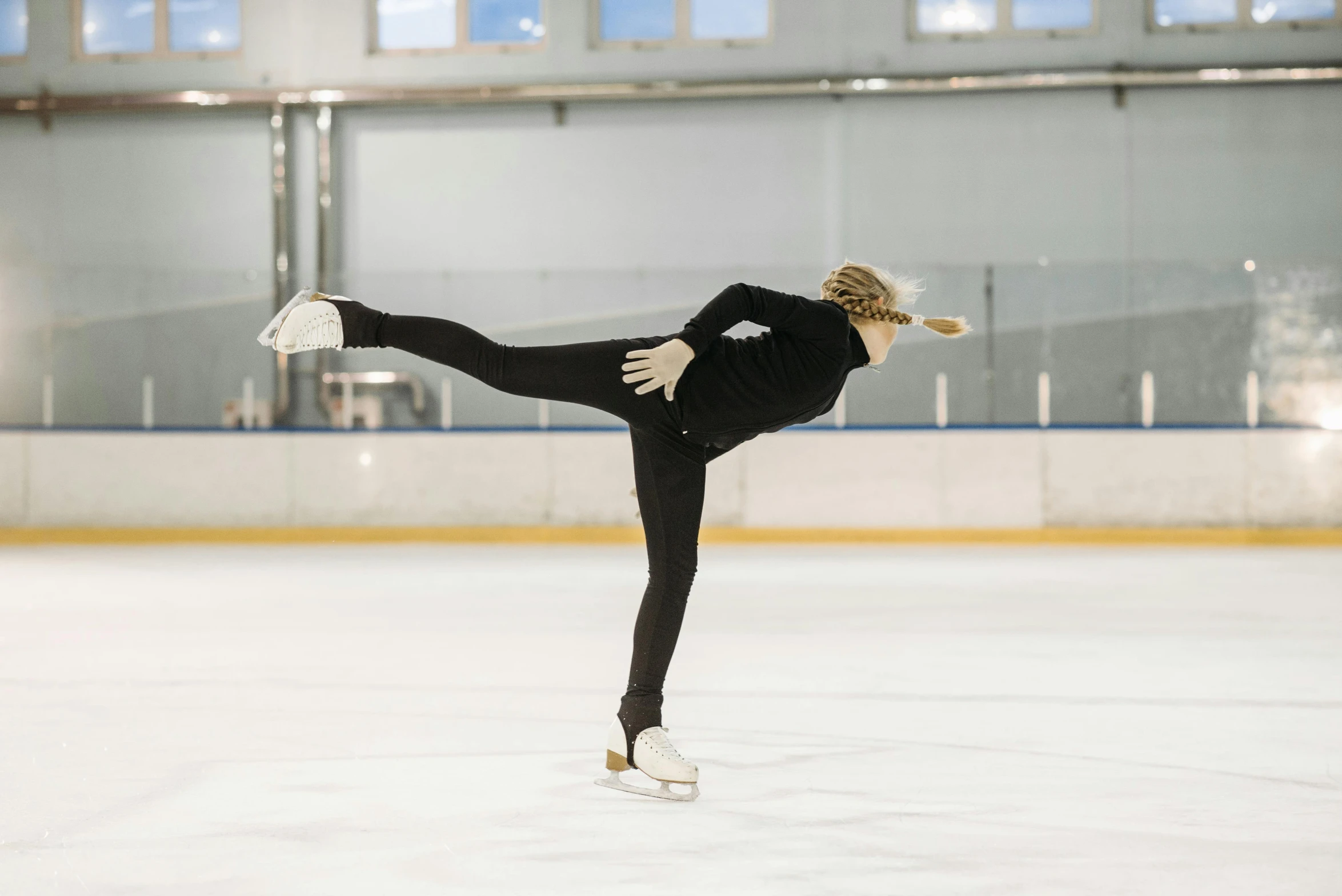 a female figure skating on an ice rink, a portrait, pexels contest winner, arabesque, wearing a tracksuit, thumbnail, black, neoprene