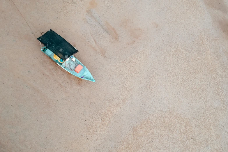 a small boat sitting on top of a sandy beach, by Elsa Bleda, unsplash contest winner, sky view, grey, samburu, videogame still