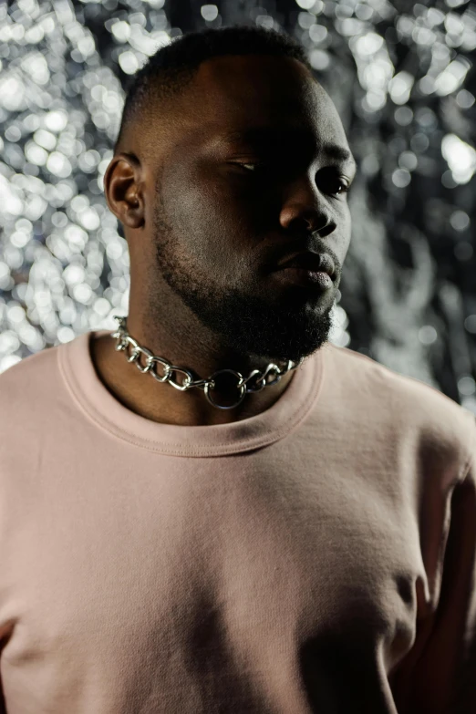 a man with a chain around his neck, an album cover, inspired by Paul Georges, trending on pexels, lyco art, huell babineaux, pink hue, wearing steel collar, demna gvasalia