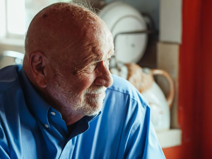 a man in a blue shirt sitting at a table, portrait of hide the pain harold, profile photo, thumbnail, colour photograph