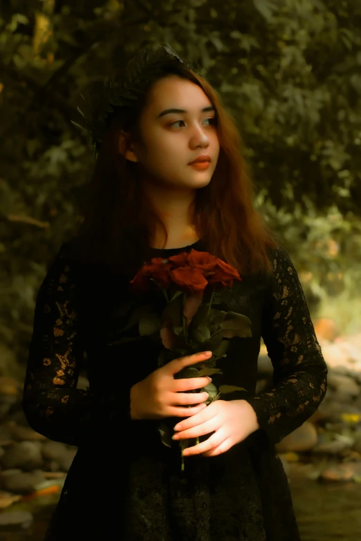 a woman in a black dress holding a red rose, inspired by Elsa Bleda, pexels contest winner, portrait of a young witch girl, ((portrait)), amidst nature, teenage girl