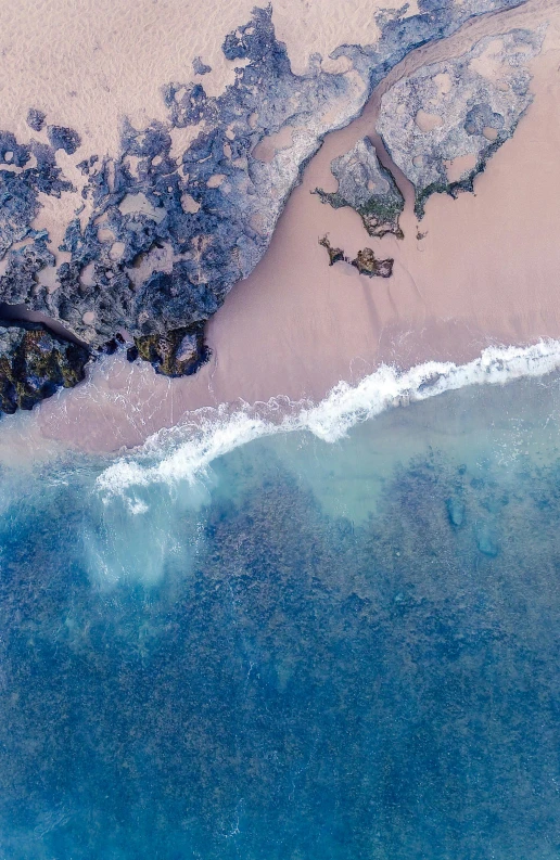 a large body of water next to a sandy beach, pexels contest winner, color aerial photo drone, blue and pink colors, turbulent water, south african coast