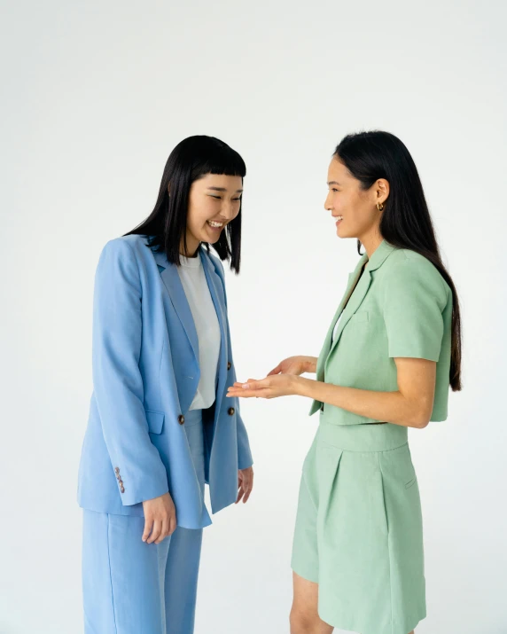 a couple of women standing next to each other, by helen huang, wearing a light blue suit, reaching out to each other, japanese collection product, unsplash transparent