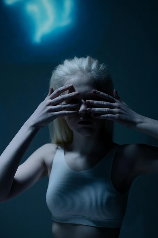 a woman covering her eyes with her hands, a hologram, inspired by Gottfried Helnwein, unsplash contest winner, aestheticism, extremely pale blond hair, horror movie lighting, blue light, photo of a model