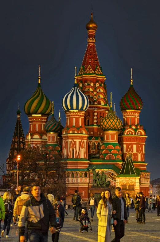 a group of people that are standing in front of a building, an album cover, inspired by Vasily Surikov, pexels contest winner, black domes and spires, night view, russian flags, rich vivid colors