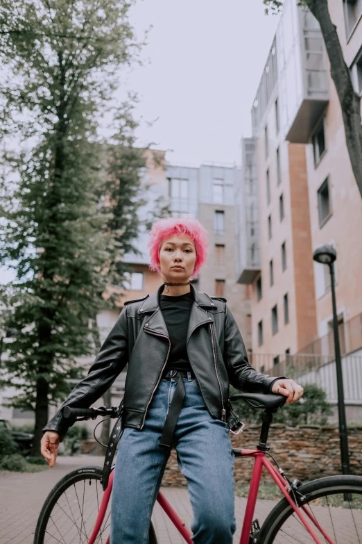 a woman with pink hair standing next to a bike, trending on pexels, dressed in short leather jacket, a young asian woman, berlin fashion, non binary future world