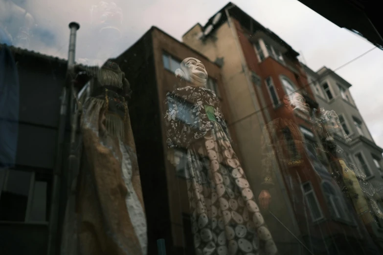 a group of mannequins in front of a building, a statue, by Attila Meszlenyi, pexels contest winner, street art, embroidered robes, window glass reflecting, turkey, by emmanuel lubezki