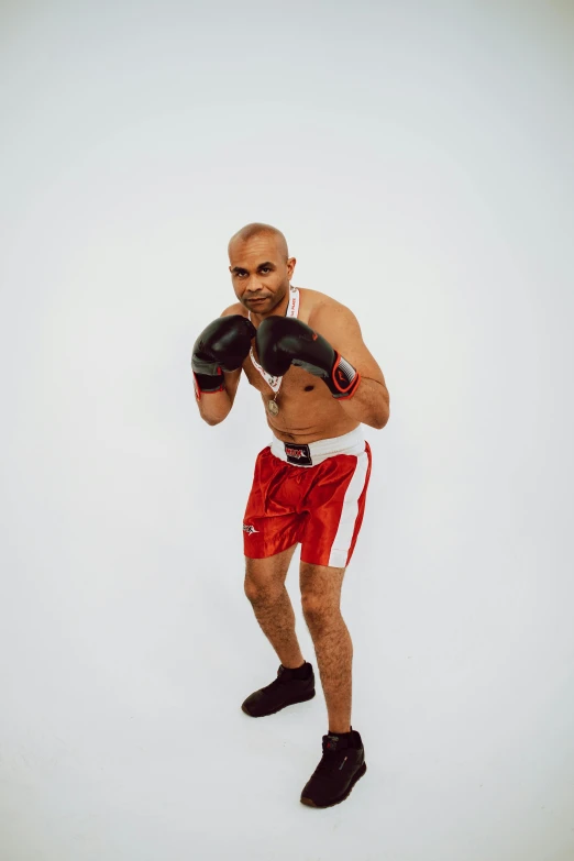 a man wearing boxing gloves posing for a picture, an album cover, inspired by Volkan Baga, pexels contest winner, figuration libre, wearing red shorts, 15081959 21121991 01012000 4k, full body action pose, (38 years old)