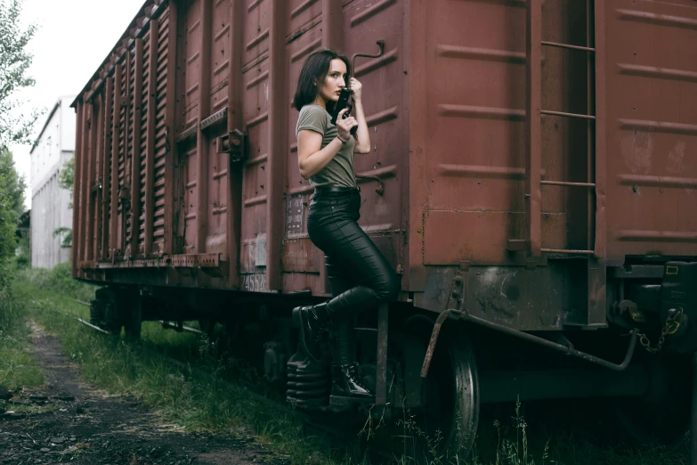a woman leaning against the side of a train, pexels contest winner, army girl outfit, leather pants, olga buzova, 🚿🗝📝