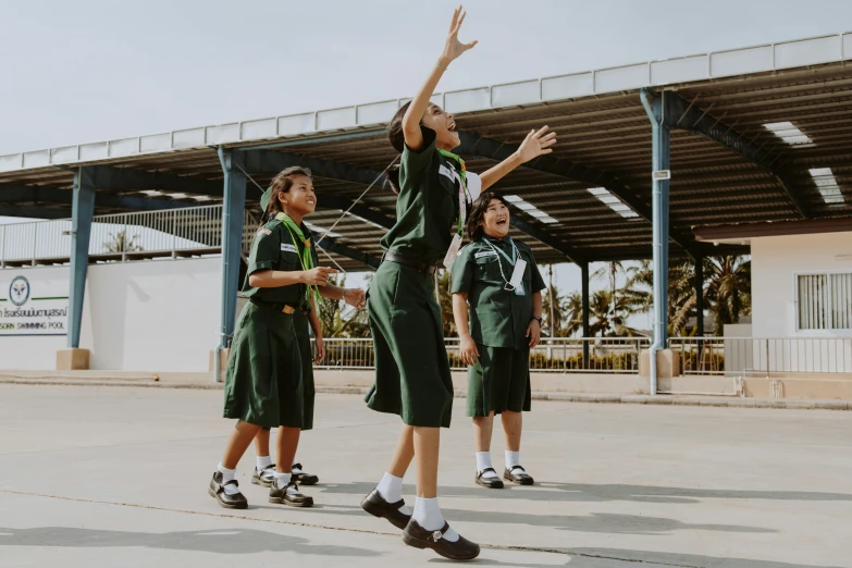 a group of young girls playing a game of basketball, an album cover, pexels contest winner, school uniform, a green, low angle wide shot, innovation