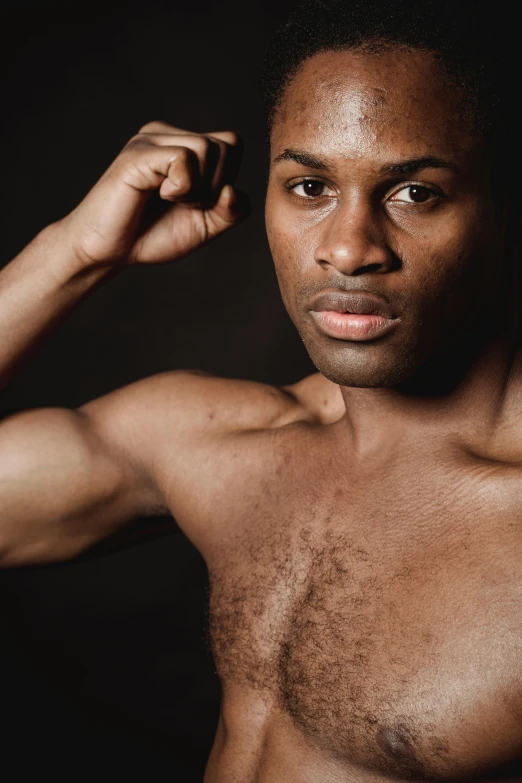 a man flexing his muscles against a black background, an album cover, inspired by Leonard Daniels, pexels contest winner, non binary model, ebony skin, square masculine facial features, handsome prince