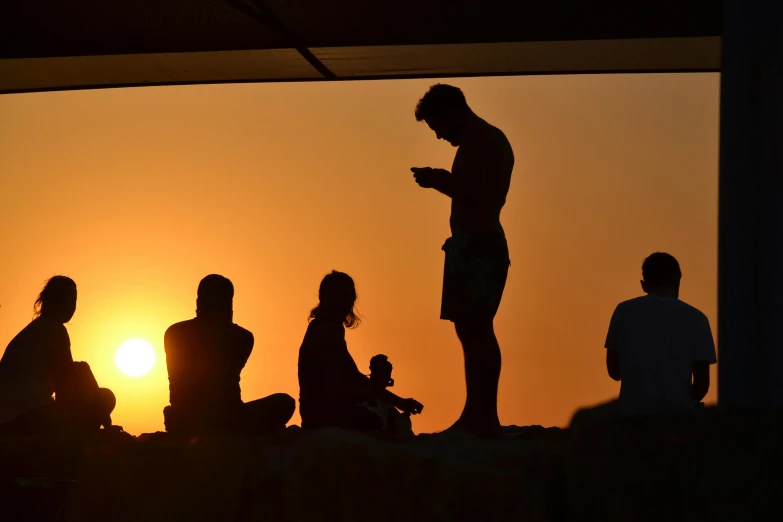 a group of people sitting and standing next to each other, by Niko Henrichon, pexels contest winner, happening, ((sunset)), tall thin, teenager hangout spot, breeding