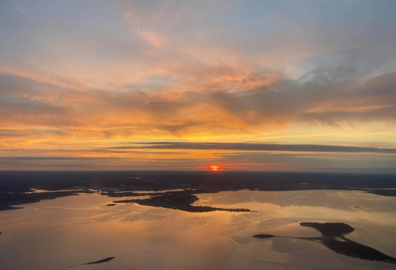 the sun is setting over a large body of water, by Jan Tengnagel, pexels contest winner, hudson river school, view from helicopter, thumbnail, 8k photo, rhode island