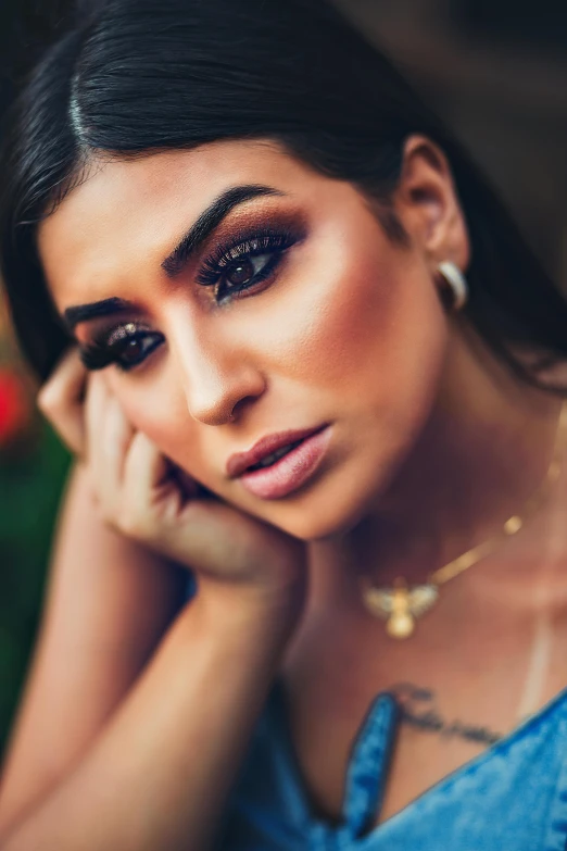 a woman in a blue dress posing for a picture, an album cover, trending on pexels, hurufiyya, bright piercing brown eyes, young middle eastern woman, with professional makeup, trending on 5 0 0 px