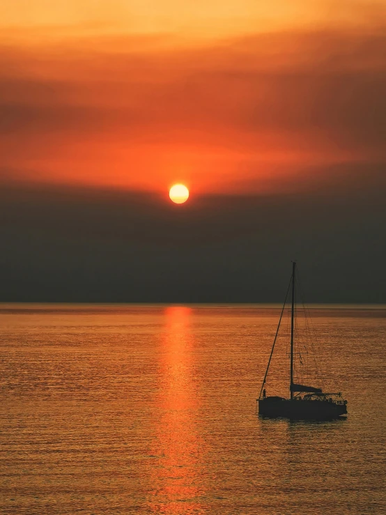 a boat floating on top of a large body of water, pexels contest winner, romanticism, orange sun set, sailboat, grey, award winning color photo