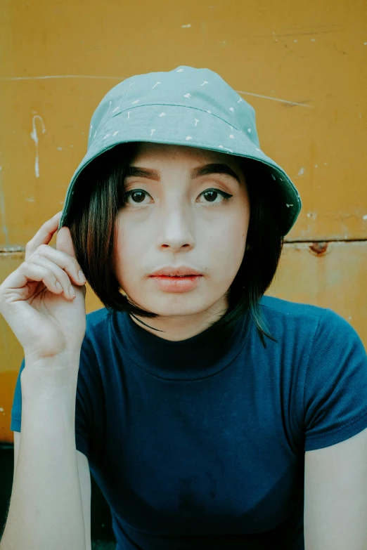 a close up of a person wearing a hat, an album cover, inspired by Yi Insang, realism, with short hair, cindy avelino, wearing casual clothing, faded color