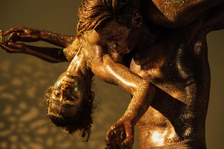 a man and a woman covered in gold paint, a bronze sculpture, pexels contest winner, figurative art, golden dappled dynamic lighting, intricate macro closeup, entwined bodies, glitter