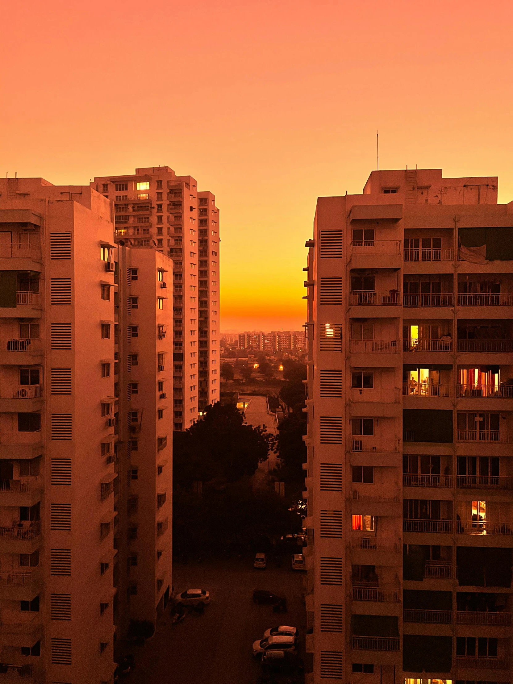 a couple of tall buildings sitting next to each other, by Benjamin Block, pexels contest winner, orange sky, apartment, plain, 4 k cinematic panoramic view