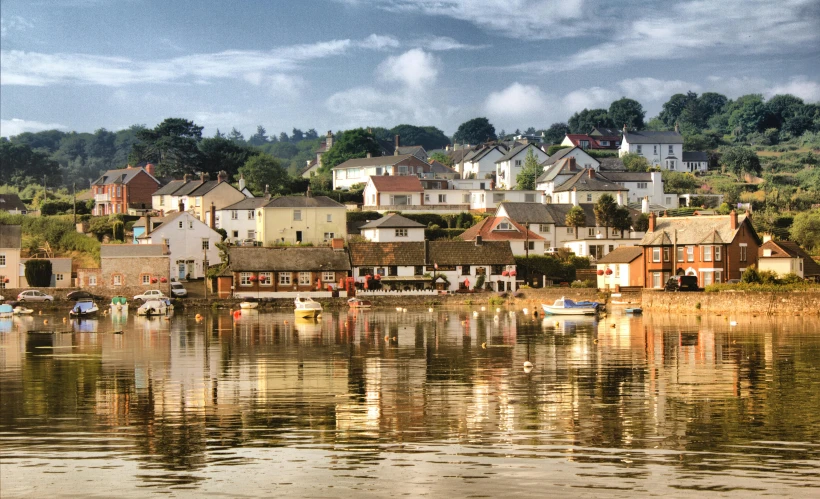 a group of boats floating on top of a lake, by Joan Ayling, pexels contest winner, pre-raphaelitism, waterfront houses, glistening gold, dean cornwall, reflections in copper