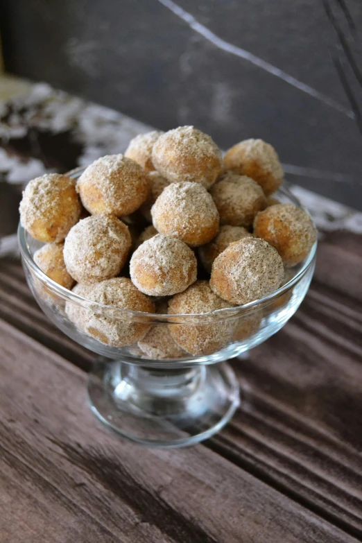 a glass bowl filled with donuts on top of a wooden table, inspired by Károly Patkó, reddit, renaissance, candies, nugget, grey, modern rustic”