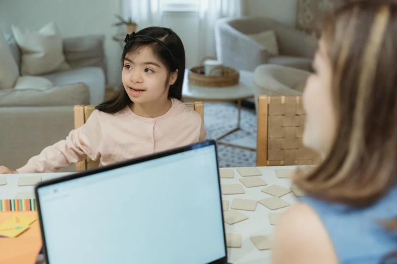 a little girl sitting at a table with a laptop, pexels contest winner, teaching, an asian woman, looking across the shoulder, early screen test