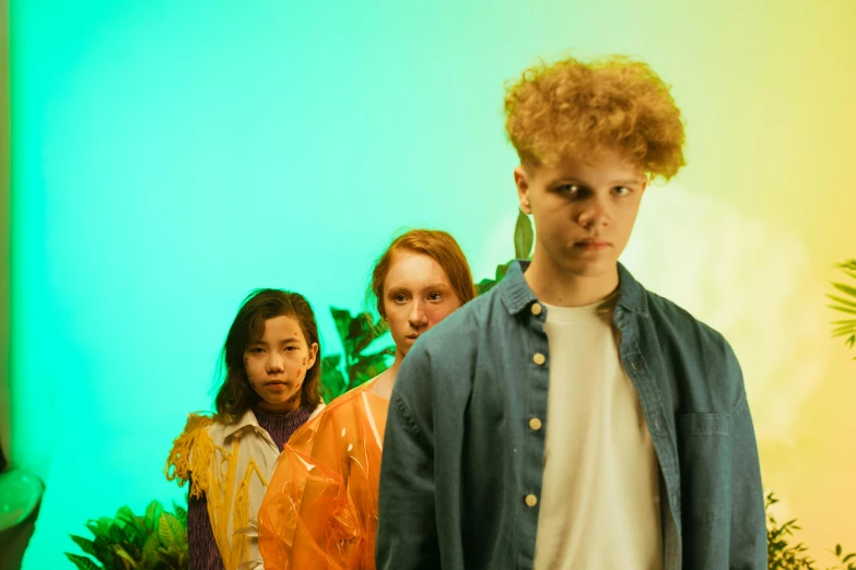 a group of people standing next to each other, an album cover, by Nathalie Rattner, pexels, red haired teen boy, neon jungle, looking threatening, midsummer