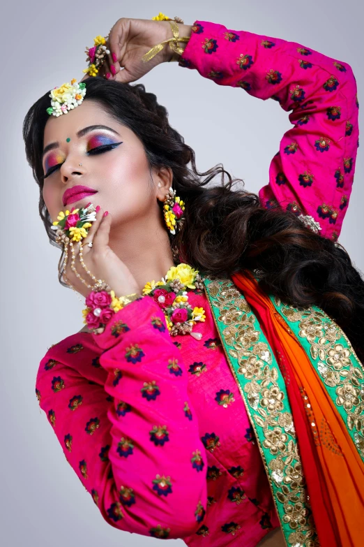 a woman in a colorful outfit posing for a picture, wearing jewellery, makeup, floral couture, bollywood