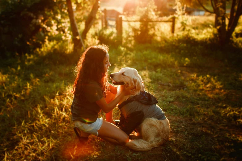 a woman sitting in the grass with a dog, by Julia Pishtar, pexels, warm golden backlit, a wooden, australian, teenage girl