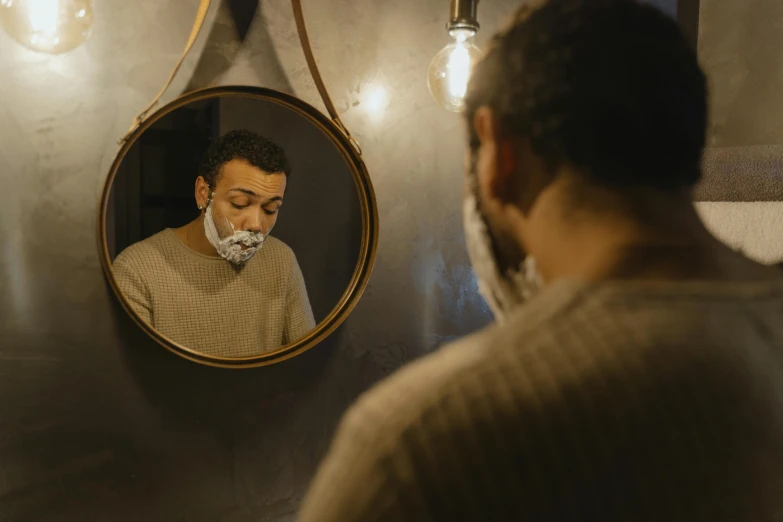 a man shaving his face in front of a mirror, pexels contest winner, renaissance, surgical mask covering mouth, black curly beard, late night, square masculine jaw